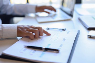 Ofiste çalışan işadamı, proje planlaması için verileri analiz ediyor.