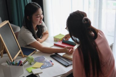 İki Asyalı kız öğrenci bir evde birlikte okuyorlar..