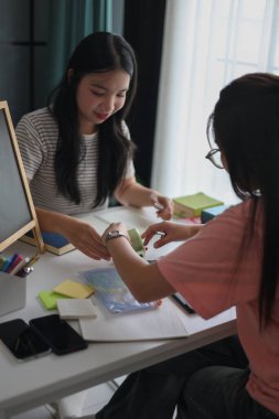 İki Asyalı kız öğrenci bir evde birlikte okuyorlar..