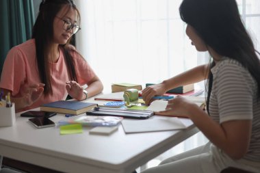 İki Asyalı kız öğrenci bir evde birlikte okuyorlar..