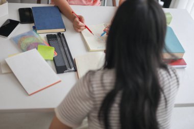 Ev ödevlerini birlikte yapan kız öğrenciler..