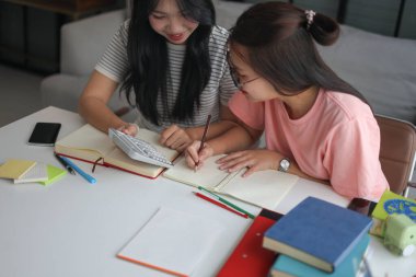 İki Asyalı kız öğrenci bir evde birlikte okuyorlar..