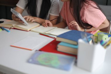 İki kadın öğrenci birlikte ödev yapıyor.