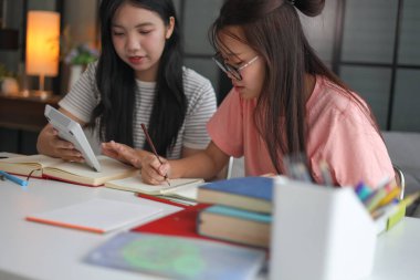 İki Asyalı kız öğrenci bir evde birlikte okuyorlar..