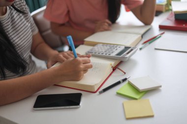 Masada ödev yapan iki kız öğrenci..