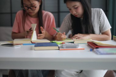 Masada ödev yapan iki kız öğrenci..