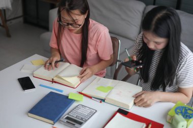 İki Asyalı kız öğrenci bir evde birlikte okuyorlar..