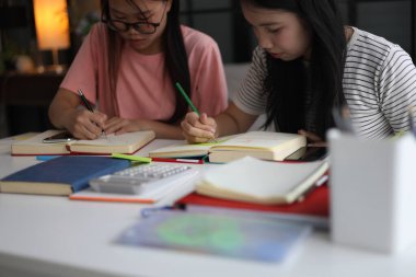 Masada ödev yapan iki kız öğrenci..