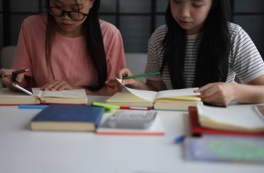 İki Asyalı kız öğrenci bir evde birlikte okuyorlar..