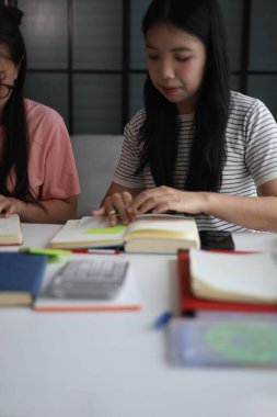 İki Asyalı kız öğrenci bir evde birlikte okuyorlar..