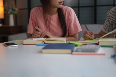 İki kadın öğrenci birlikte ödev yapıyor.