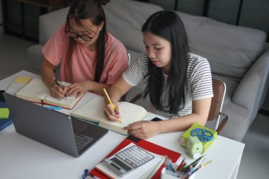 Masada ödev yapan iki kız öğrenci..