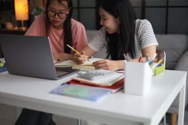 İki Asyalı kız öğrenci bir evde birlikte okuyorlar..