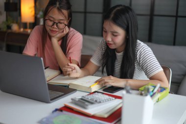 İki Asyalı kız öğrenci bir evde birlikte okuyorlar..