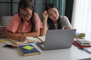 İki Asyalı kız öğrenci bir evde birlikte okuyorlar..