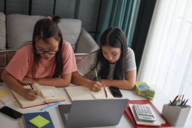 Masada ödev yapan iki kız öğrenci..