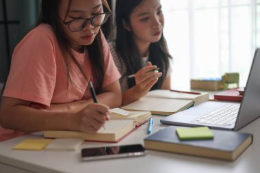 İki Asyalı kız öğrenci bir evde birlikte okuyorlar..