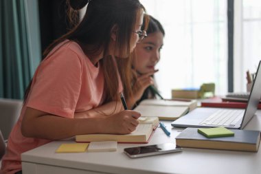Masada ödev yapan iki kız öğrenci..
