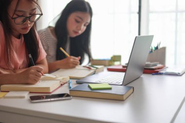 İki Asyalı kız öğrenci bir evde birlikte okuyorlar..