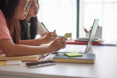 İki Asyalı kız öğrenci bir evde birlikte okuyorlar..