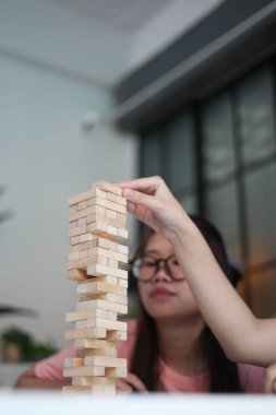 İki genç bayan arkadaş evlerinde tahta kule blokları masa oyunu oynuyorlar..