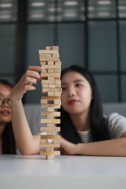 Beyaz bir masada ahşap kule oyunu oynayan iki kişiye yaklaş..