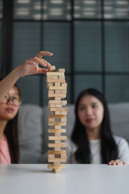 Beyaz bir masada ahşap kule oyunu oynayan iki kişiye yaklaş..