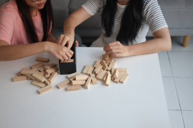 Beyaz bir masada ahşap kule oyunu oynayan iki kişiye yaklaş..