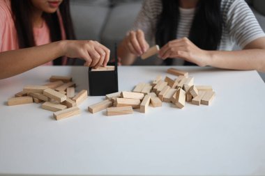 Beyaz bir masada ahşap kule oyunu oynayan iki kişiye yaklaş..