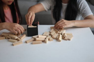 Beyaz bir masada ahşap kule oyunu oynayan iki kişiye yaklaş..