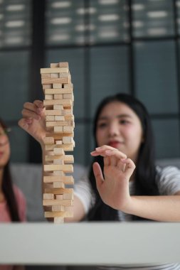 Beyaz bir masada ahşap kule oyunu oynayan iki kişiye yaklaş..