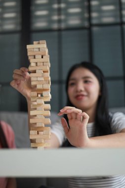 İki genç bayan arkadaş evlerinde tahta kule blokları masa oyunu oynuyorlar..