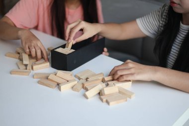 Beyaz bir masada ahşap kule oyunu oynayan iki kişiye yaklaş..