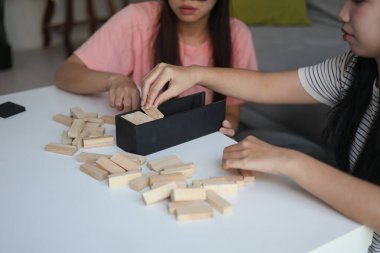 Beyaz bir masada ahşap kule oyunu oynayan iki kişiye yaklaş..