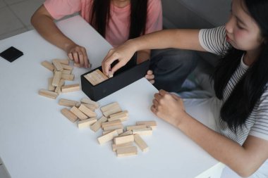 Beyaz bir masada ahşap kule oyunu oynayan iki kişiye yaklaş..