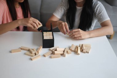 Beyaz bir masada ahşap kule oyunu oynayan iki kişiye yaklaş..