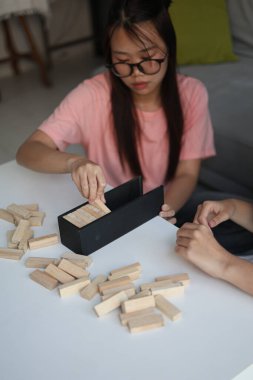 Beyaz bir masada ahşap kule oyunu oynayan iki kişiye yaklaş..