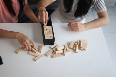 Beyaz bir masada ahşap kule oyunu oynayan iki kişiye yaklaş..