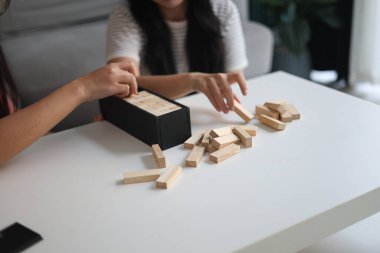 Beyaz bir masada ahşap kule oyunu oynayan iki kişiye yaklaş..