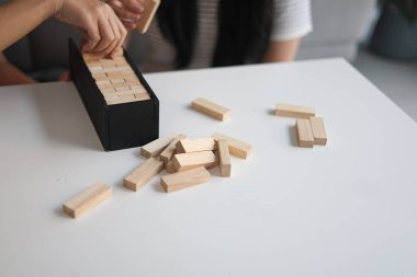 Beyaz bir masada ahşap kule oyunu oynayan iki kişiye yaklaş..