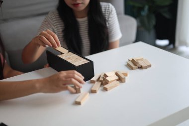 Beyaz bir masada ahşap kule oyunu oynayan iki kişiye yaklaş..