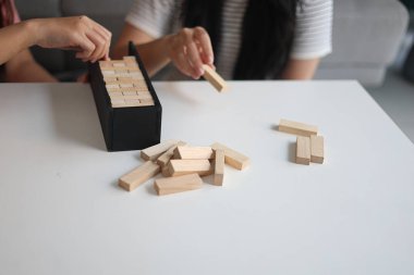 Beyaz bir masada ahşap kule oyunu oynayan iki kişiye yaklaş..