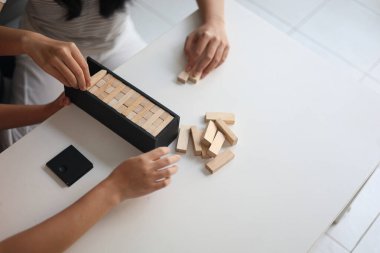 Beyaz bir masada ahşap kule oyunu oynayan iki kişiye yaklaş..