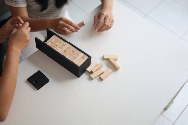 Beyaz bir masada ahşap kule oyunu oynayan iki kişiye yaklaş..