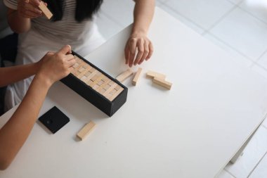 Beyaz bir masada ahşap kule oyunu oynayan iki kişiye yaklaş..