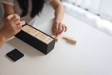 Beyaz bir masada ahşap kule oyunu oynayan iki kişiye yaklaş..