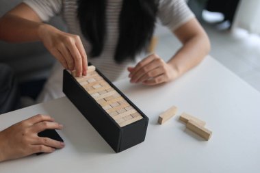 Beyaz bir masada ahşap kule oyunu oynayan iki kişiye yaklaş..