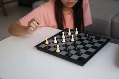 Evde birlikte satranç oynayan iki genç bayan arkadaş..