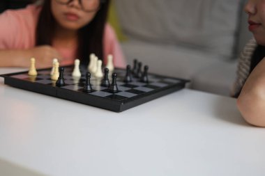 Evde birlikte satranç oynayan iki genç bayan arkadaş..