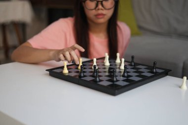 Evde birlikte satranç oynayan iki genç bayan arkadaş..